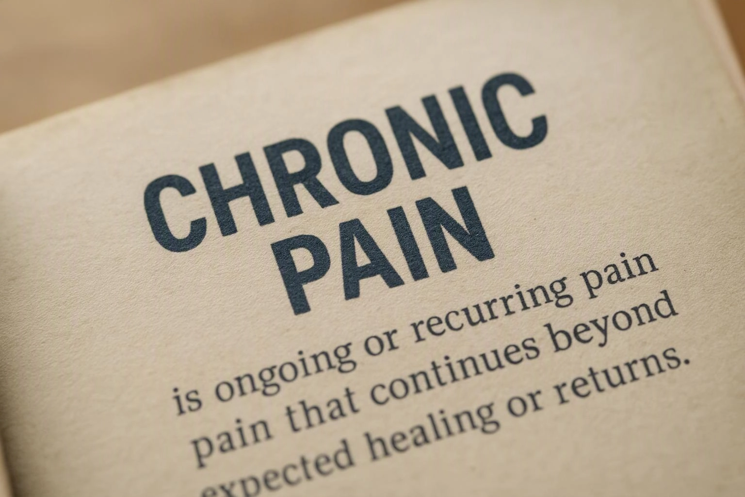 A tilted close-up of a printed page shows the heading chronic pain with a short definition underneath